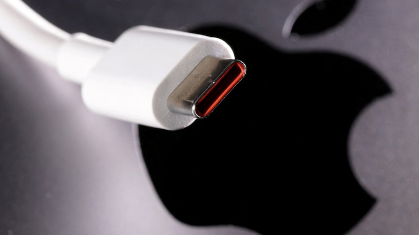 A USB-C cable in front of an Apple logo.
