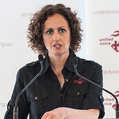 Jess Walsh stands before a microphone.