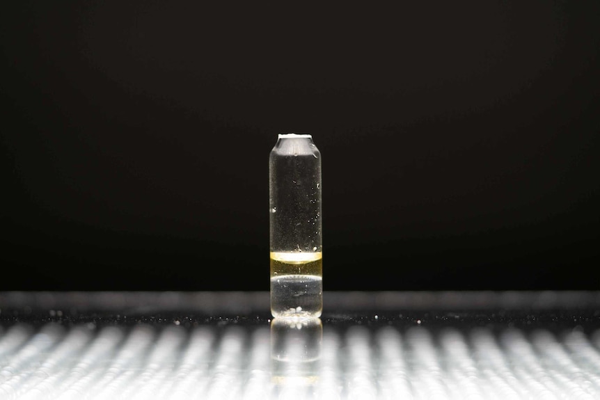 a yellow substance in small vial.