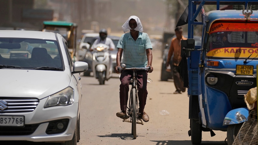 A man riding a bike in heat. 