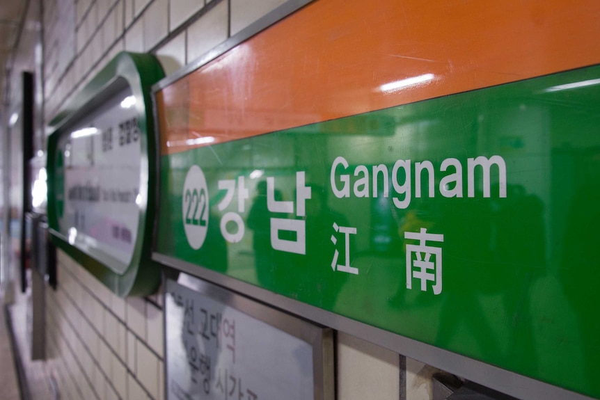 A sign for 'Gangnam Station'.