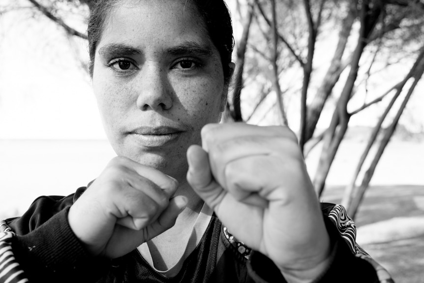 Portrait of woman holding fists up.