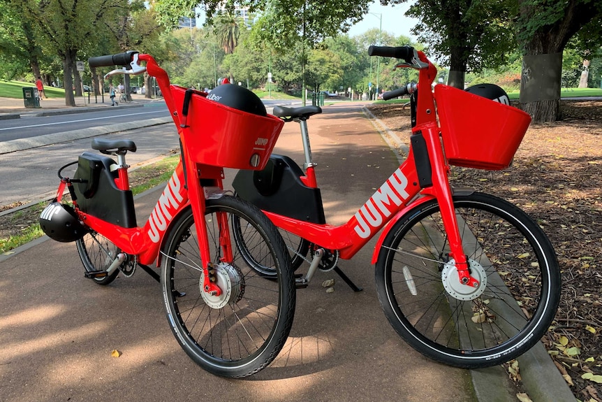 Two red electric bikes outdoors in Melbourne.
