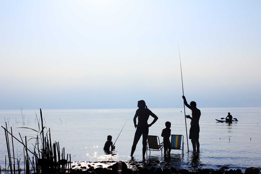 Silhouette of a family fishing at the beach