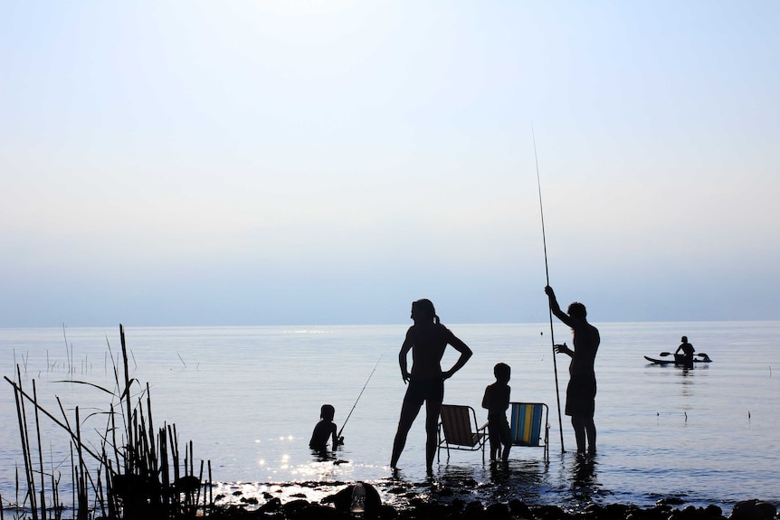 Silhouette of a family fishing at the beach