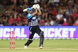 An Adelaide Strikers batsman stands just out of his crease with arms extended having hit the ball down the ground.