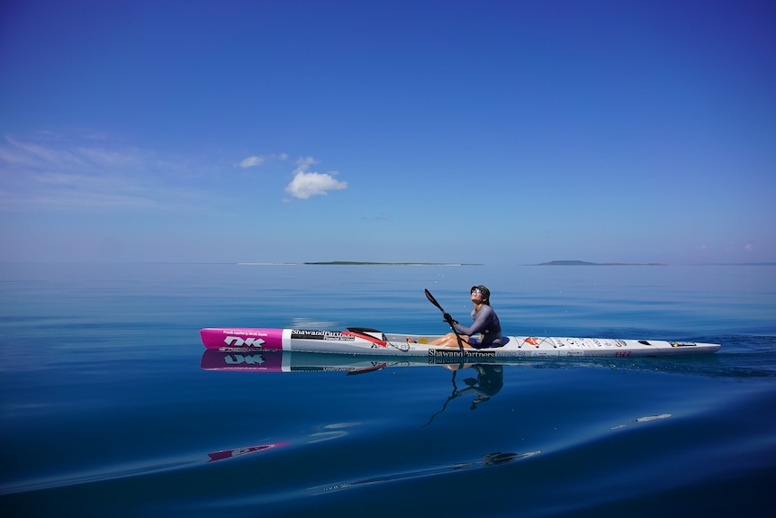 woman paddling canoe in ocean