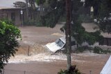 A car washed against a tree in floodwaters on Wheatley St in North Bellingen in New South Wales