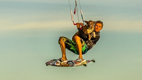 Man and dog on kitesurfer