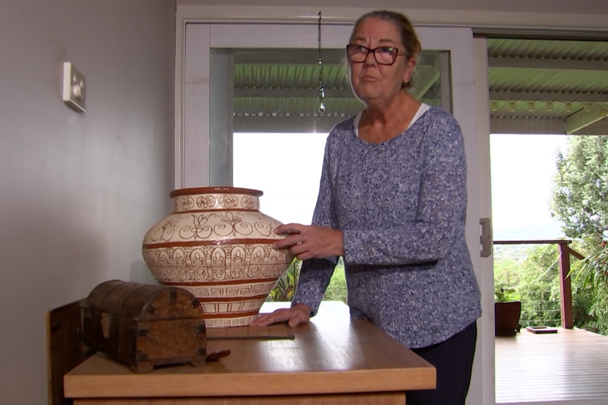 Eine Frau berührt eine große Keramikvase