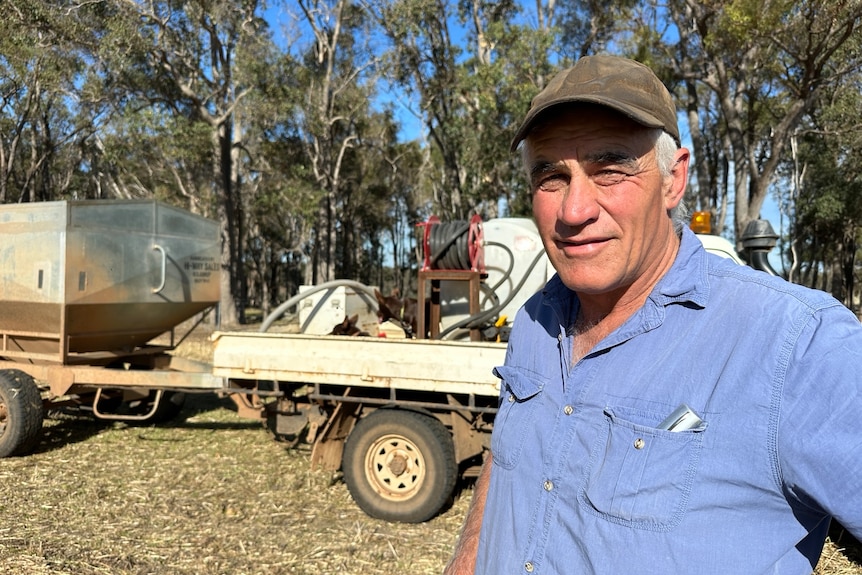 A farmer named Peter Reid wears a cap and stands in front of a ute.