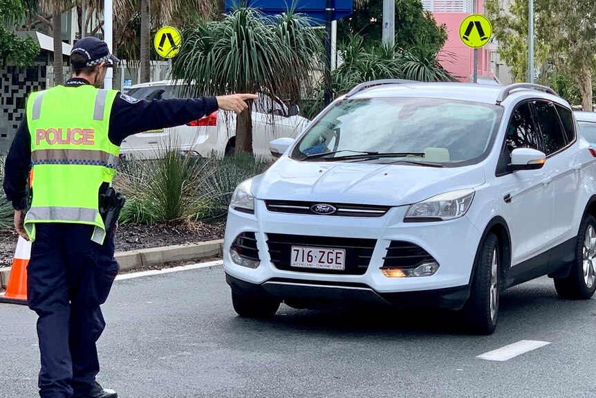 Police direct traffic at the Griffith Street border check point