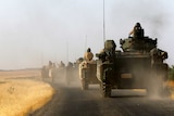 Turkish armoured personnel carriers drive towards the border.