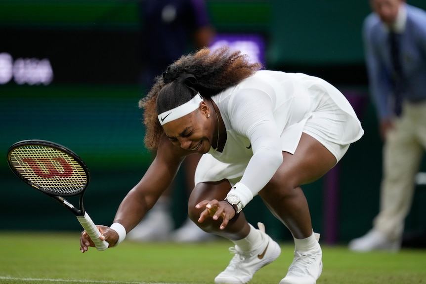 Serena Williams grimaces in pain as she falls forward with her arms out on Centre Court at Wimbledon.