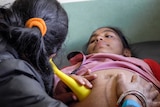 A nurse at the Bhotechaur clinic uses a 3D printed fetoscope on a pregnant woman.