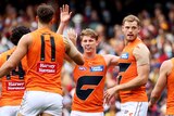GWS players stand around and high five Lachie Whitfield