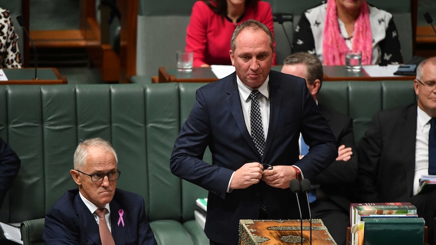 Barnaby Joyce buttons his jacket as he stands by malcolm turnbull in the house of reps