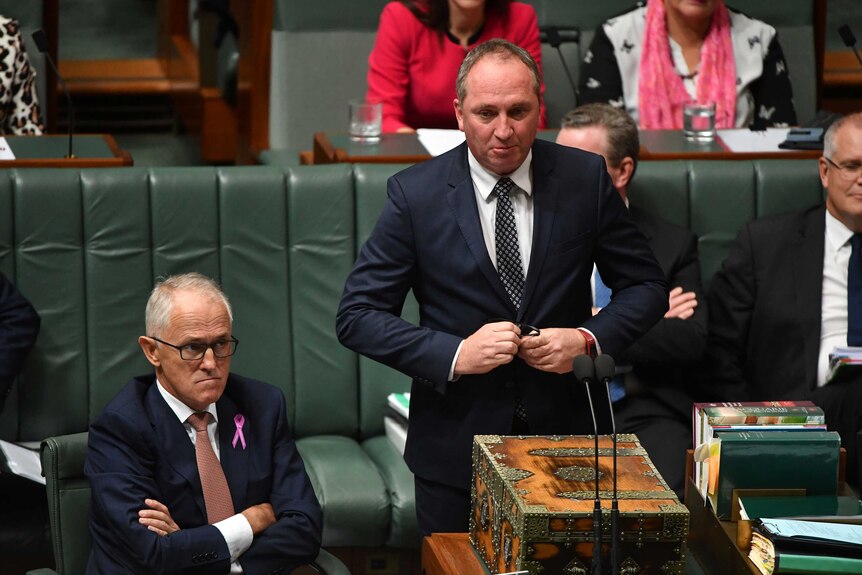 Barnaby Joyce buttons his jacket as he stands by malcolm turnbull in the house of reps