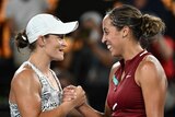 Two female tennis players shake hands at the net after an Australian Open match.