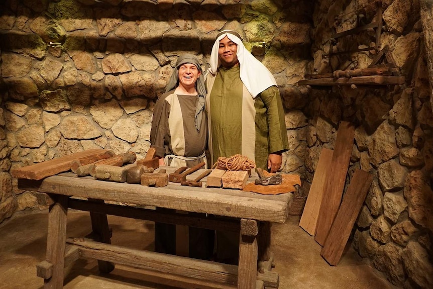 Actors dressed as first century carpenters standing smiling in the Museum of the Bible