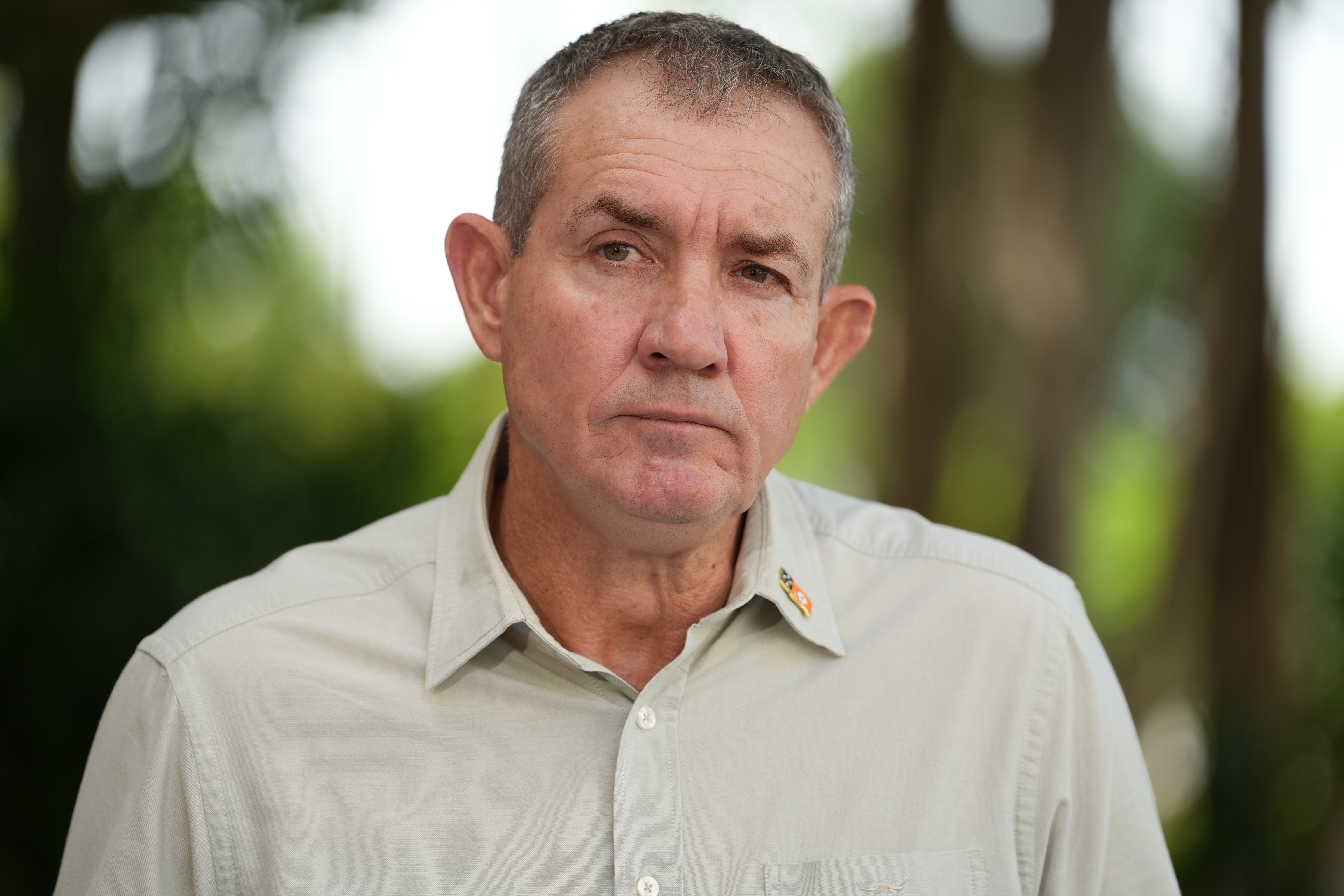 Man in light shirt looks to someone to his right