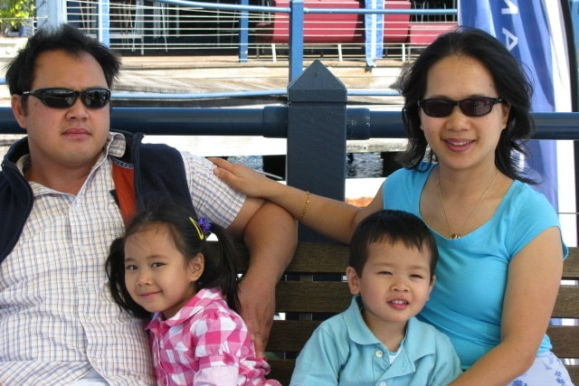 A family sitting together beside a lake