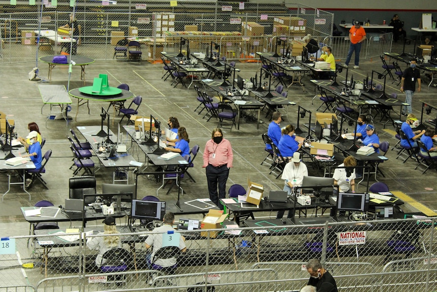 The audit as seen from the stands, featuring tables of volunteers sorting ballots