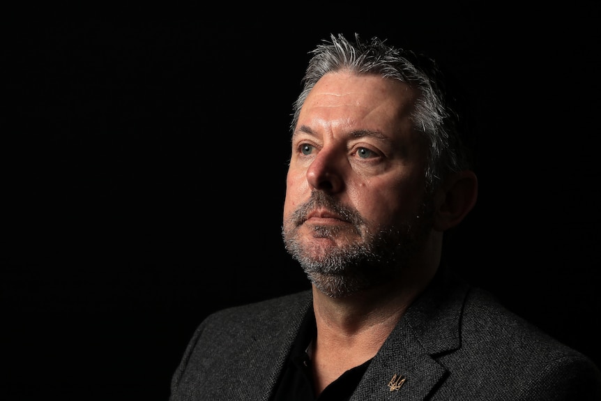 Man sits in dark room 