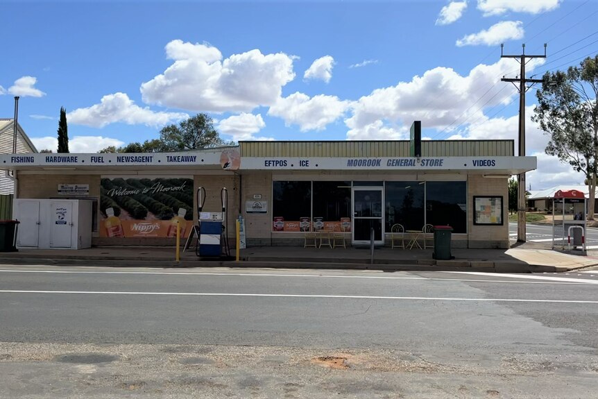 The front of a store with a sign that reads Moorook General Store, next to a road with a blue sky in the background.