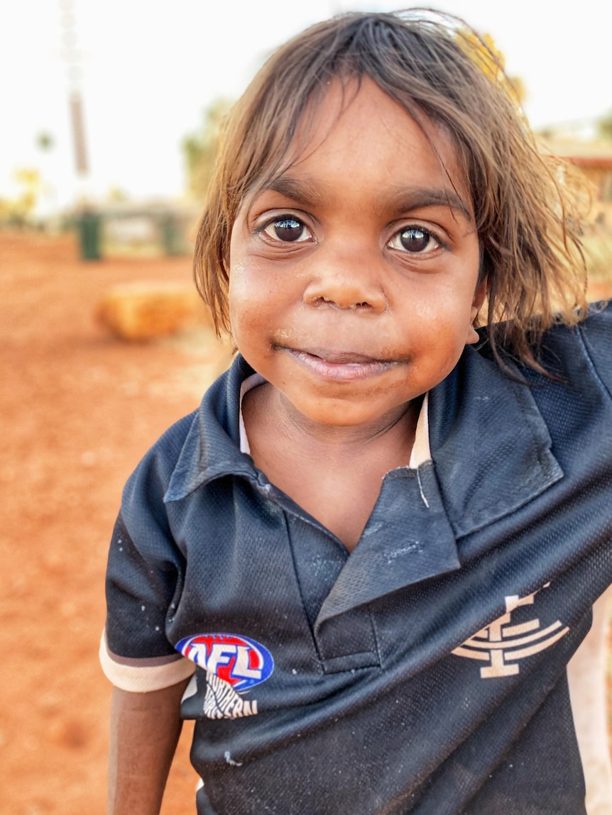 A young girl looks towards the camera.