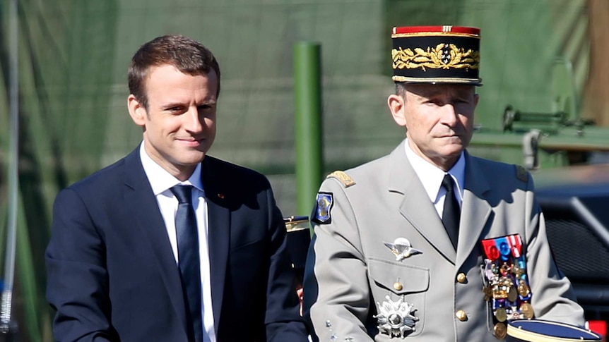 Emmanuel Macron and Pierre de Villiers stand next to each other during a Bastille Day parade.