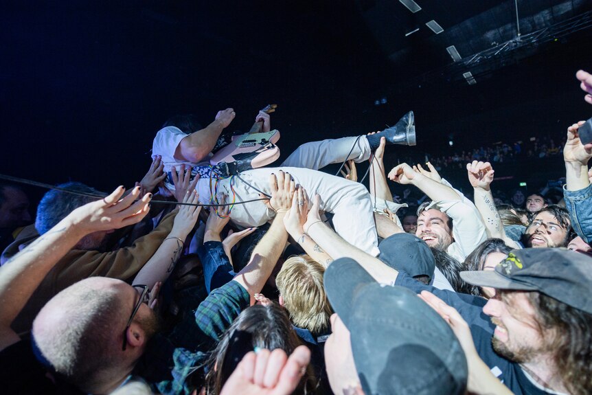 IDLES guitarist Lee Kiernan crowdsurfs over the audience at Melbourne's Festival Hall