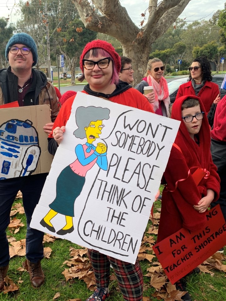  A woman and a boy holding signs 