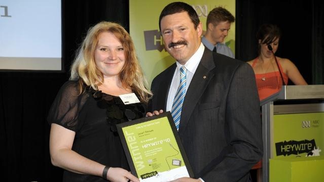Teenage girl smiles while receiving award