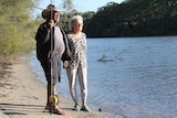 Jackie McDonald and her partner Geoffrey Togo stand with a fishing rod on the Cobaki Broadwater near where they live