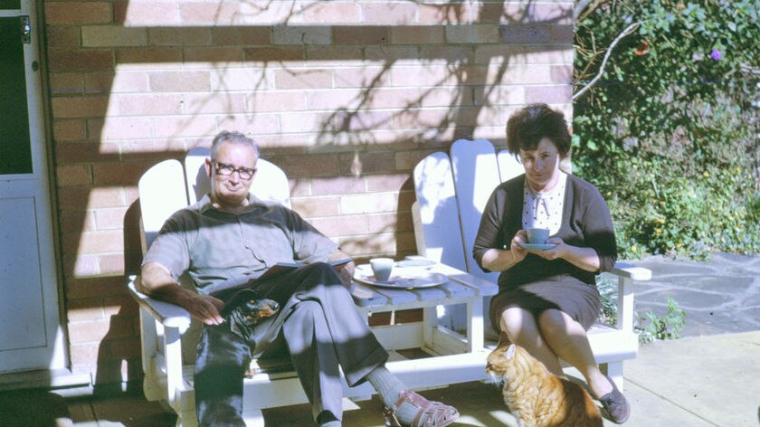 Photo of a couple aged in the 70s sitting outside in garden.