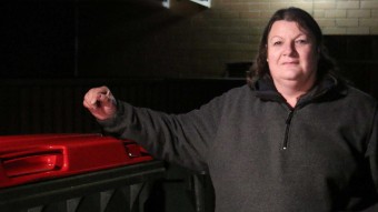 Tracey Phillips leans on a large industrial bin.