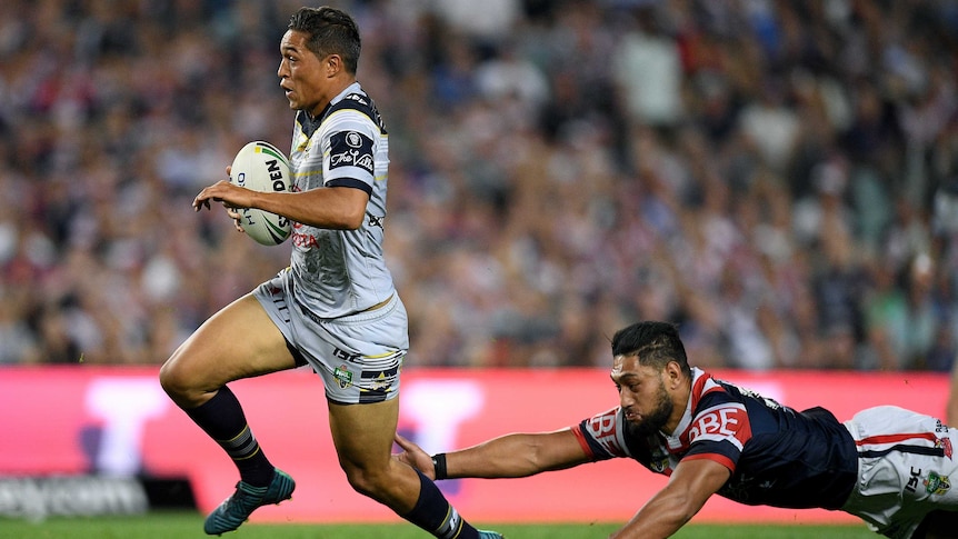 The Cowboys' Te Maire Martin evades a tackle by Roosters' Issac Liu to score a try in the prelim.