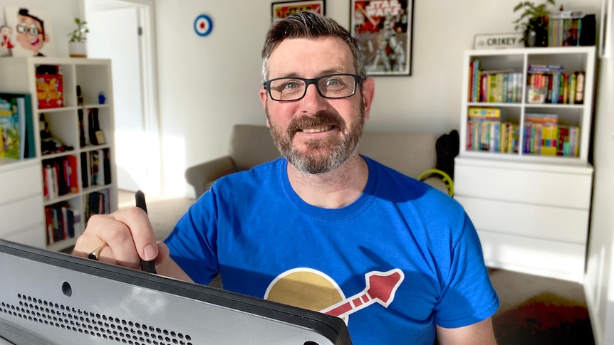 a man with grey and black hair sits at a computer