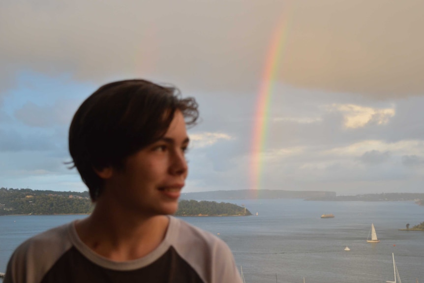 Cooper Rice-Brading with a rainbow in the background.