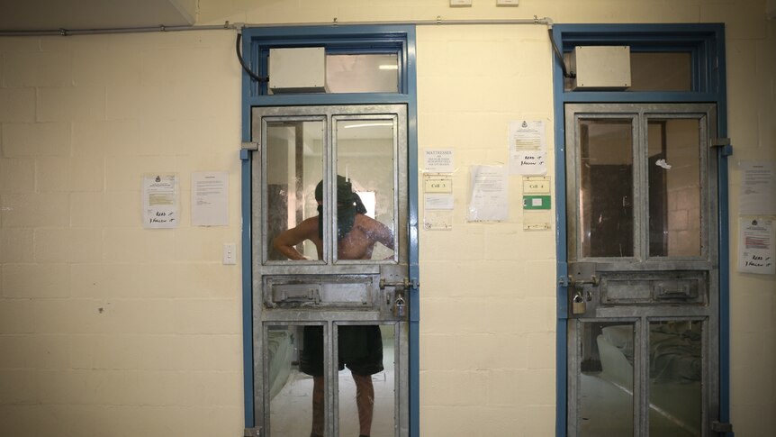 Inmate stands against cell door