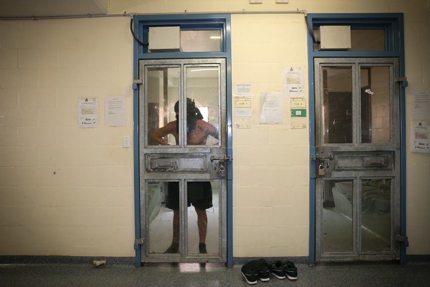 Inmate stands against cell door