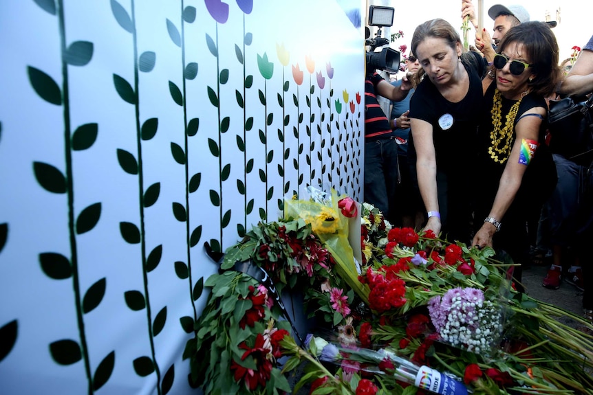 Women put flowers at the site where Shira Banki was stabbed to death