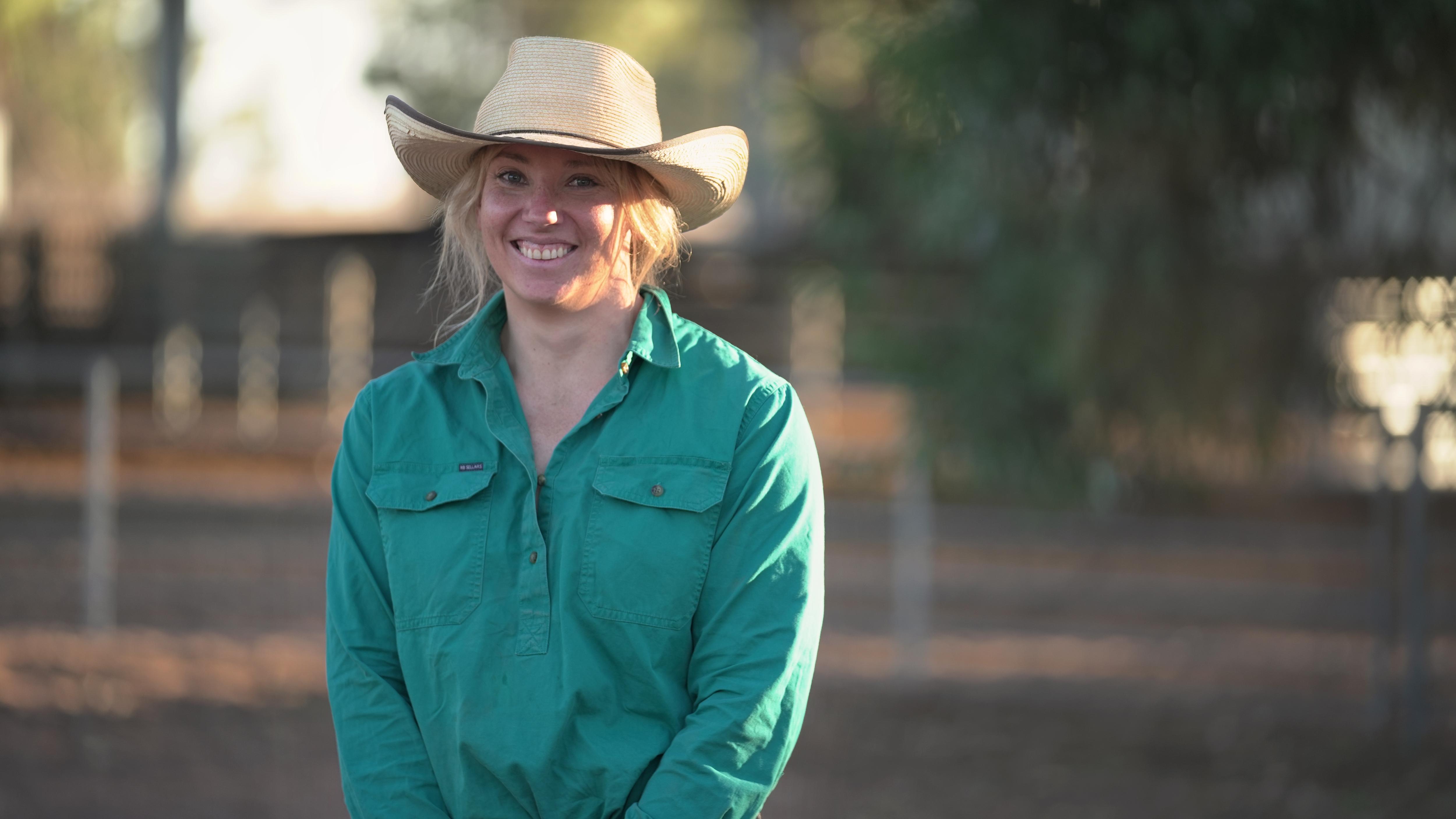 A woman standing in front of a farm station.