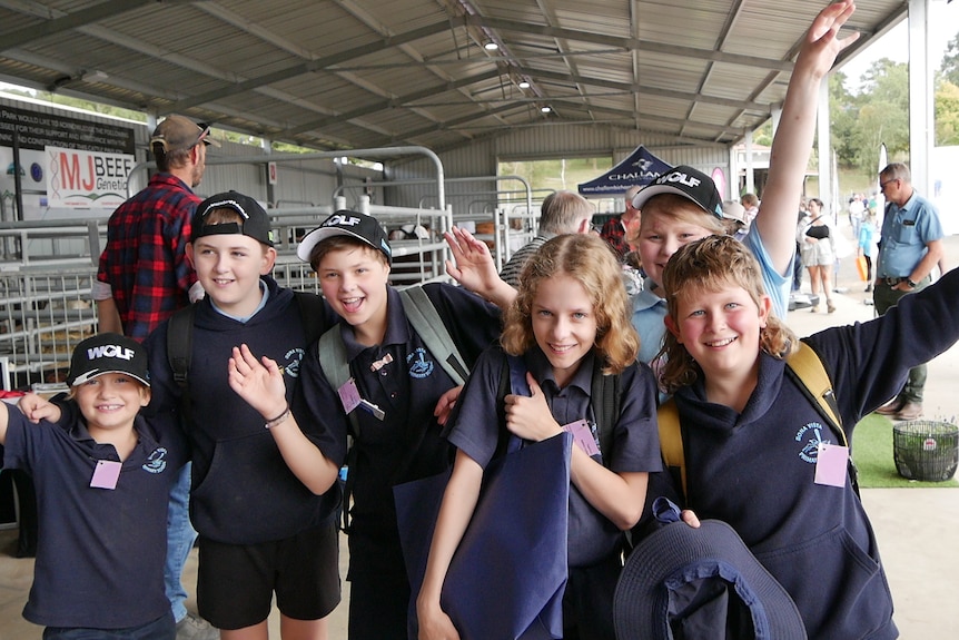 A group of primary school students throwing their hands in the air in celebration.