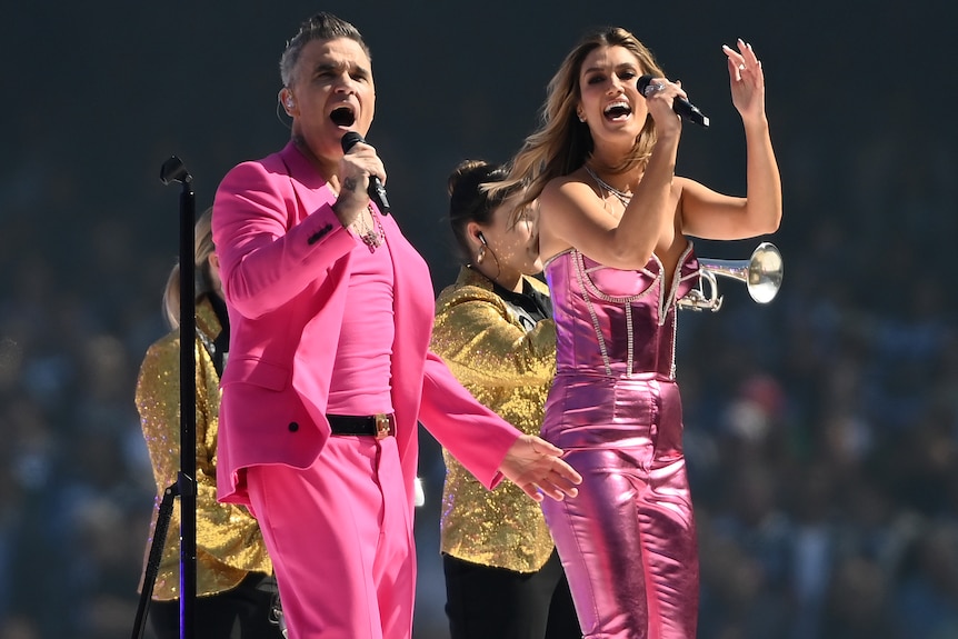 Robbie Williams and Delta Goodrem perform during the 2022 AFL grand final pre-match show.