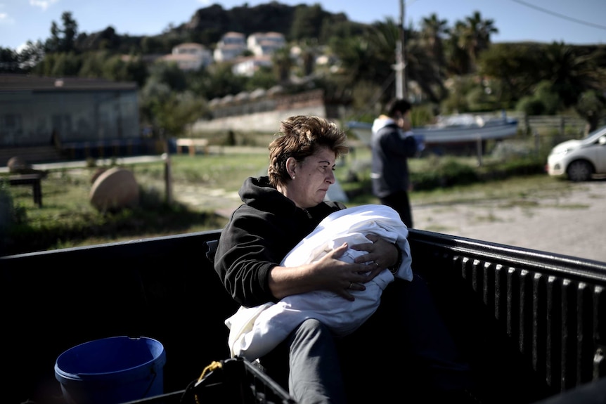 A woman holds the body of a dead baby in Lesbos