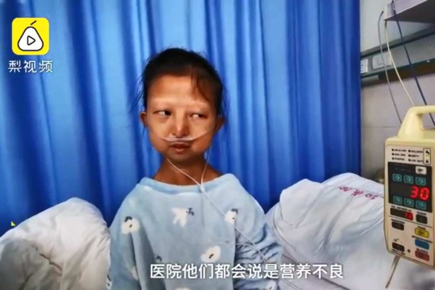 Chinese student Wu Huayan speaks in an interview sitting beside a bed in hospital.