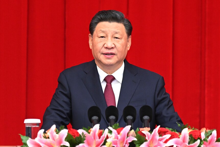 Chinese President Xi Jinping stands at a lectern delivering a speech.