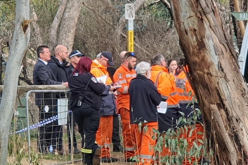 Group of emergency personnel in orange uniform in shrublands